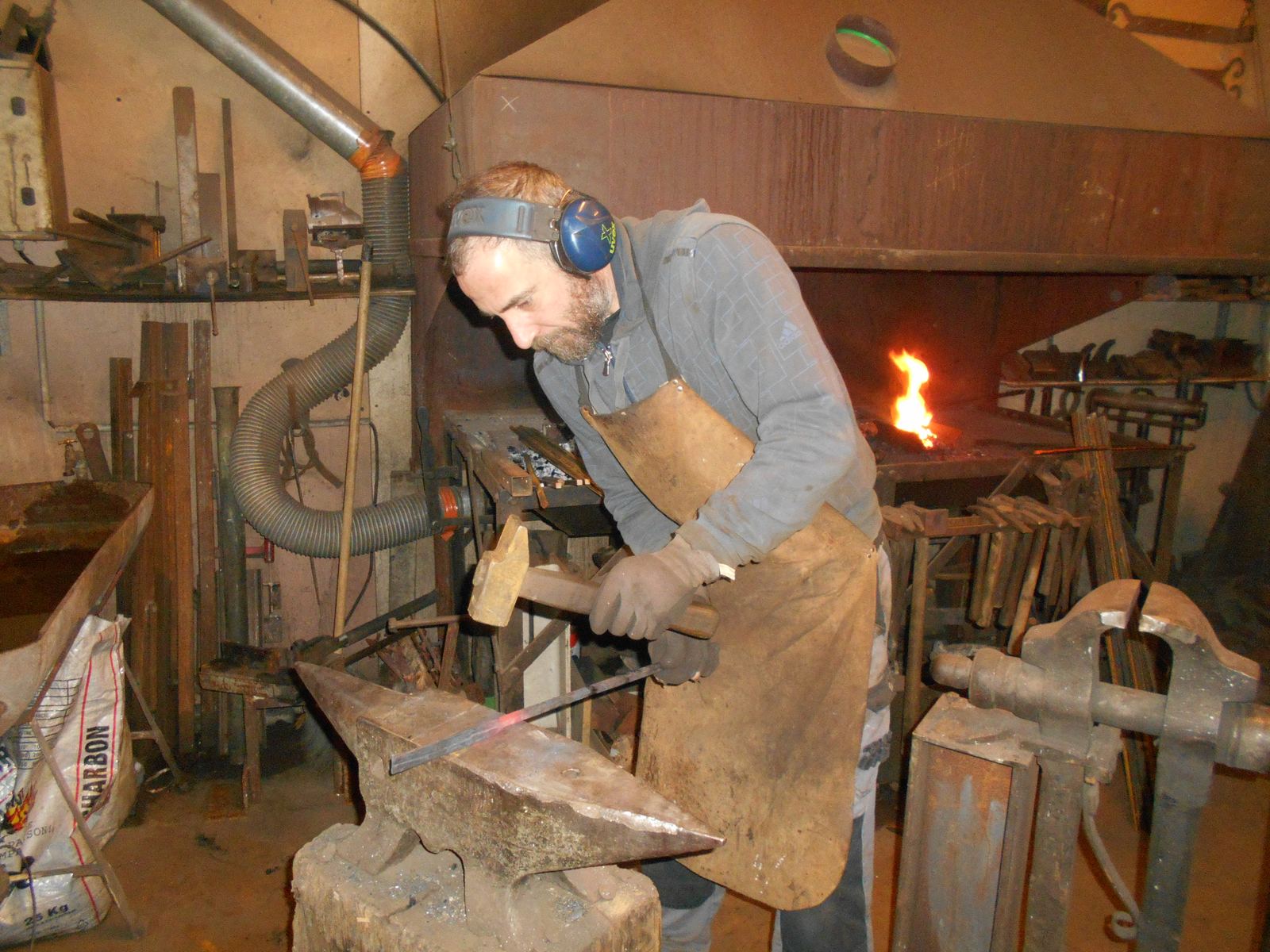 Forgeron façonnant des clous de porte à la forge