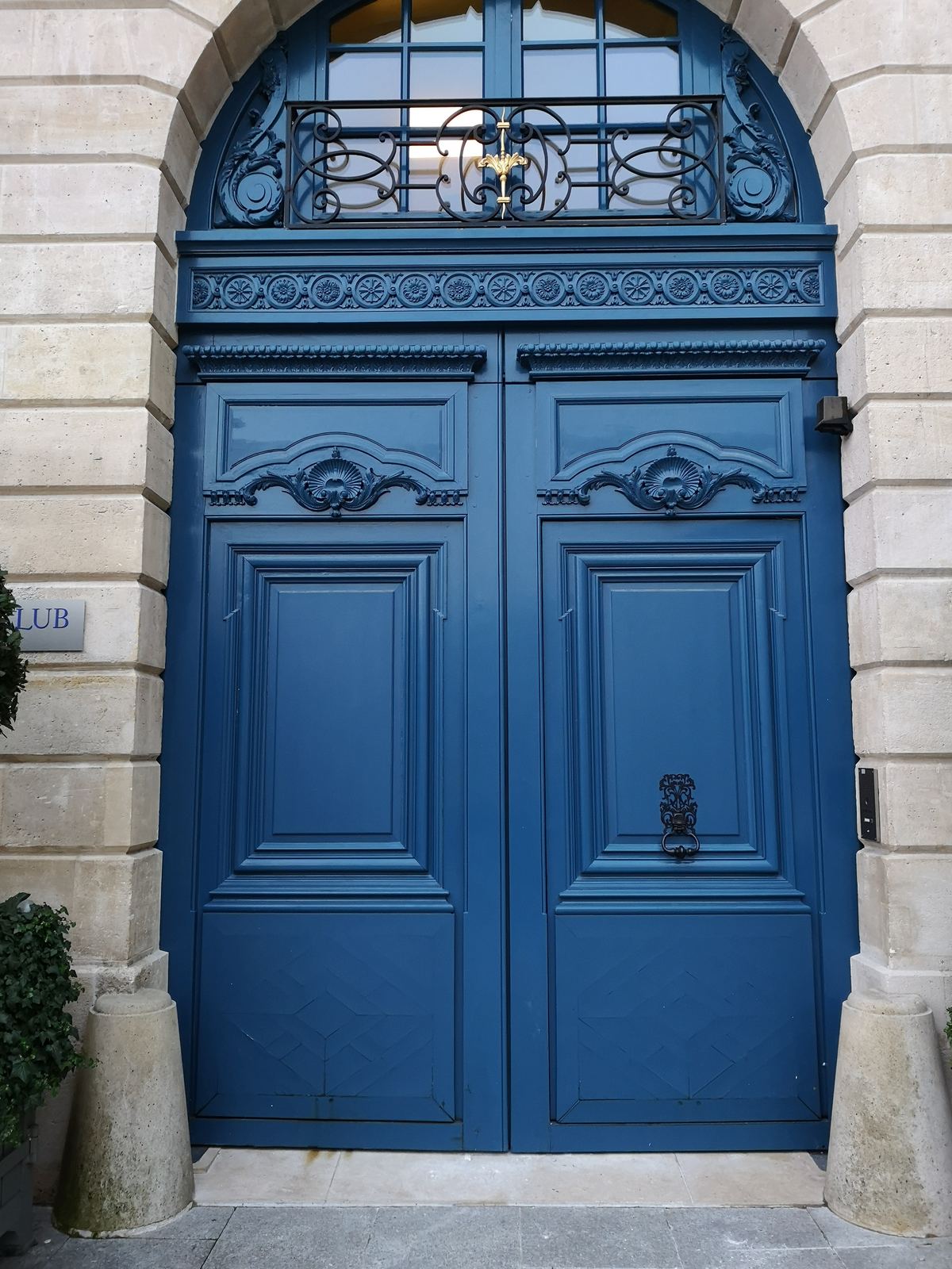Porte cochère en bois peinte en bleu, restaurée, dans une façade en pierre à Paris